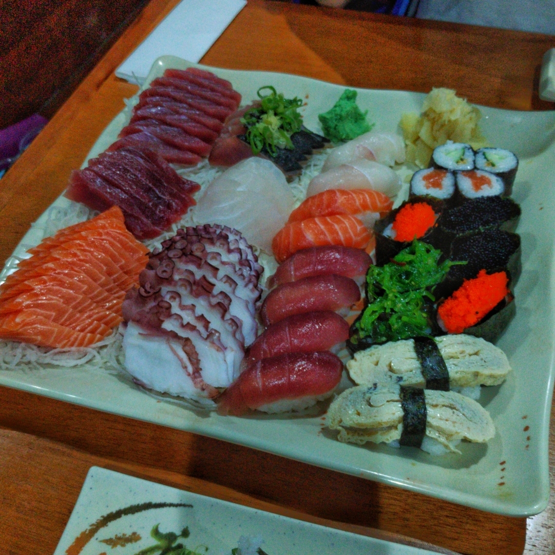 foto de um prato de sushis e sashimis variados, com diferentes peixes (salmão, atum, carapau), polvo, ovas, algas e tamagoyaki.