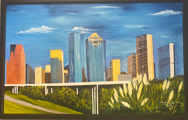 A painting of the houston skyline in a frame.
