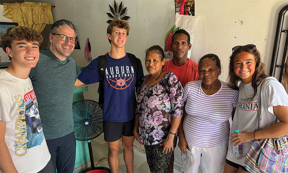 Church mission team visiting local family during outreach trip.