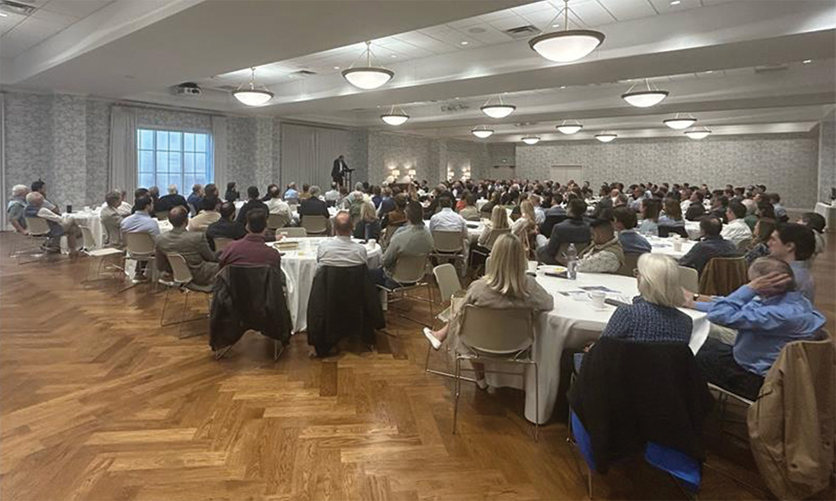 Large church gathering seated at round tables listening to speaker.